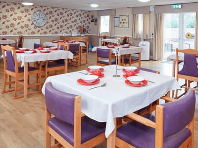 Dining area with set tables and a floral wallpaper