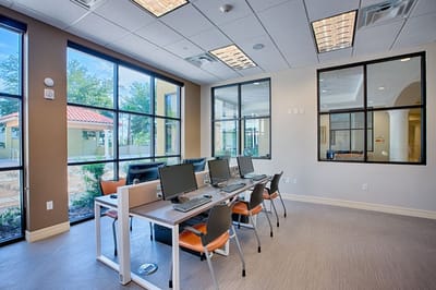 Bright common area with computers and large windows.