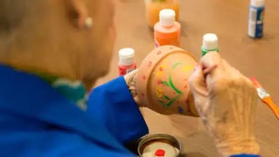 Resident painting a flower pot during an activity.