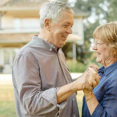Two seniors enjoying a dance outdoors