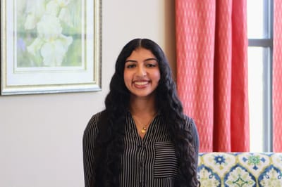 Smiling young woman in a cozy interior setting.