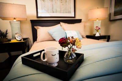 Cozy bedroom setup with flowers and a mug