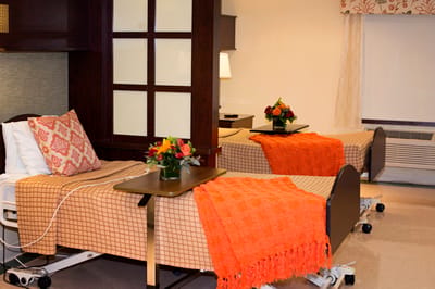Cozy resident room with floral decor and warm blankets.