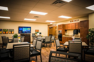 Dining area with tables and kitchen appliances.