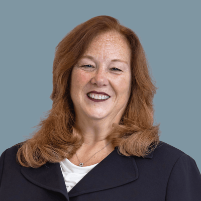 Portrait of a smiling staff member in dark clothing.