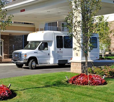 Facility shuttle bus near entrance and flowers.