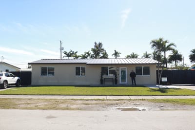 Exterior view of an assisted living facility with a staff member outside