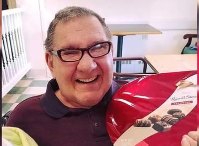 Resident smiling with a plate of assorted chocolates