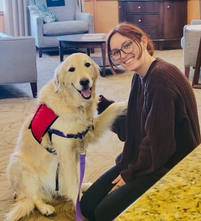 A resident with a therapy dog in a cozy common area
