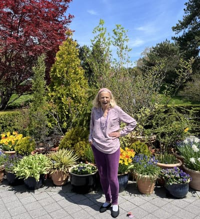 Resident posing in a vibrant outdoor garden space