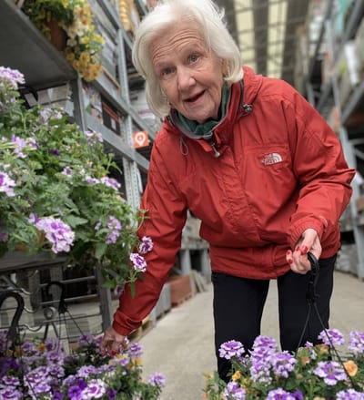 Senior woman enjoying flowers at a garden center