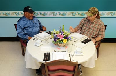 Two residents enjoying a meal together at a dining table