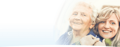 Smiling elderly woman with caregiver outdoors