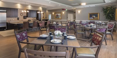 Dining area set for a meal with floral centerpieces
