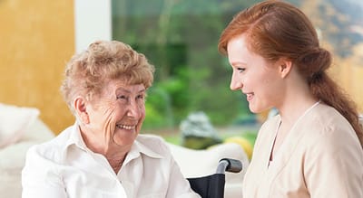A caregiver interacting warmly with a resident