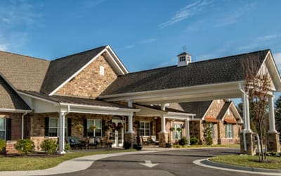 Exterior view of a senior living facility with porch seating