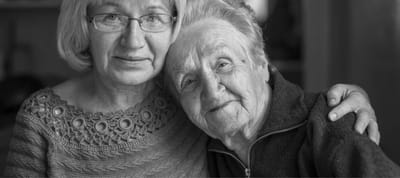 Two smiling senior women embracing each other