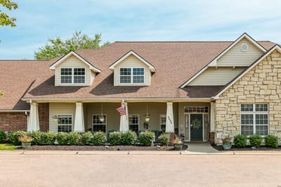 Exterior view of a senior living facility with gardens