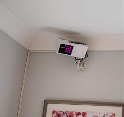 Ceiling-mounted electronic device in a room corner