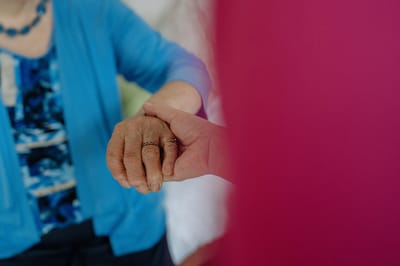 Two hands clasped together, showing connection.