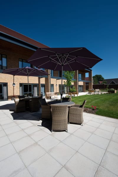 Outdoor seating area with umbrellas and green lawn