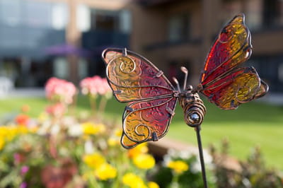 Colorful butterfly sculpture in a vibrant garden