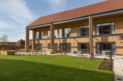 Exterior view of the facility with outdoor seating and gardens