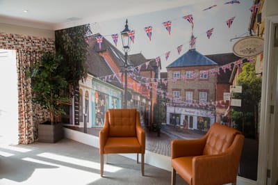 Interior photo with chair and mural of a town square