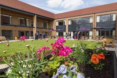 Residents enjoying a garden space with flowers and seating