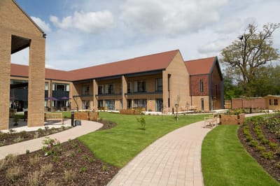 Exterior view of a senior living facility with landscaped gardens
