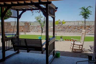 Swing set overlooking a landscaped garden.