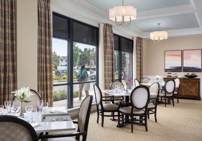 Bright dining room with tables set for residents