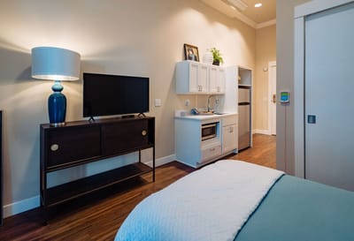 Cozy resident room with kitchenette and TV