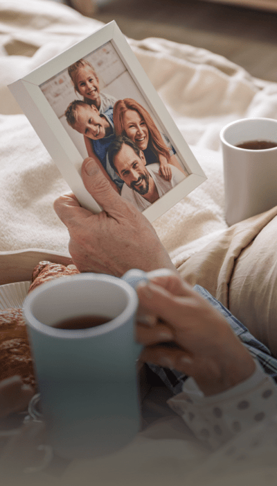 A senior holding a photo frame with a family picture