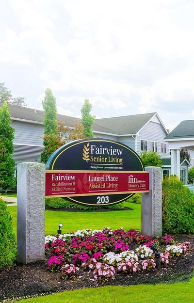 Sign for Fairview Senior Living with flower beds