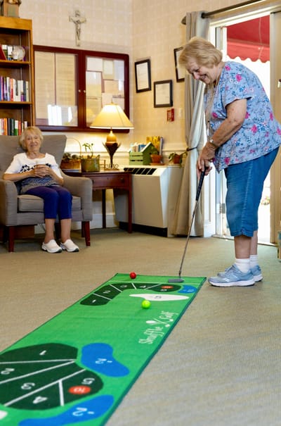 Residents enjoying an indoor putting activity