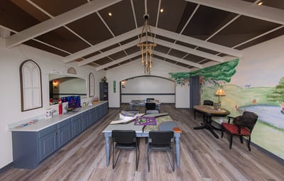 Bright interior common area with tables and mural