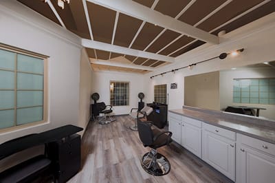 A salon area with styling chairs and mirrors