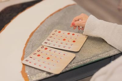 A resident playing bingo with game cards