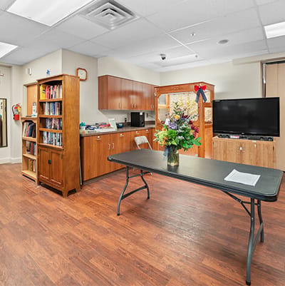 Bright common area with a table and a bookshelf