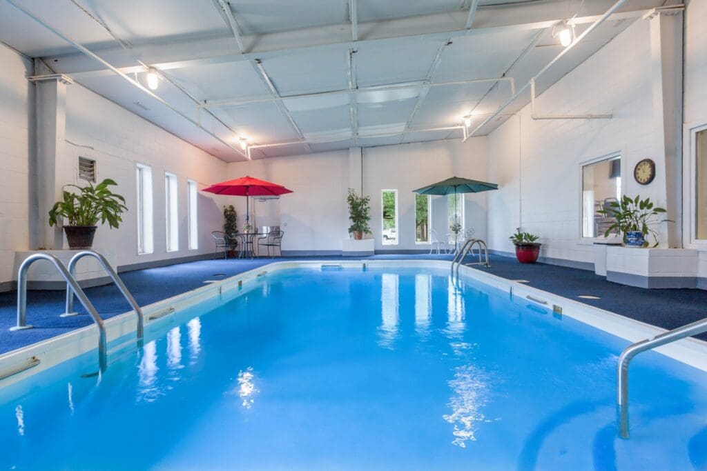 Indoor swimming pool with seating and umbrellas