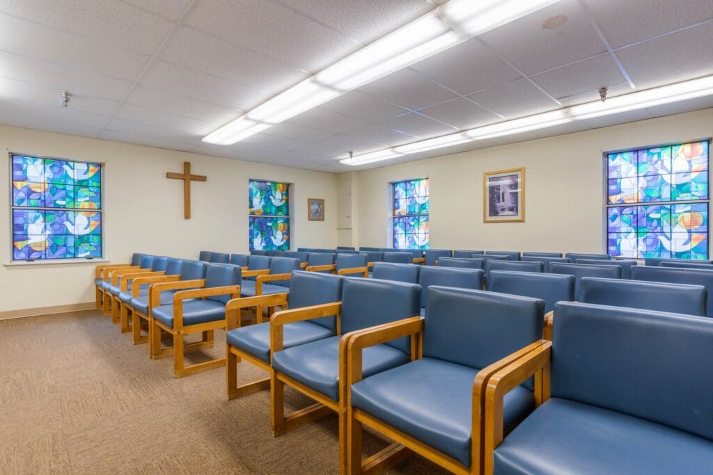 Interior view of a meeting room with chairs and colorful windows