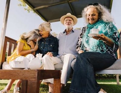 Residents enjoying tea under a shaded outdoor area