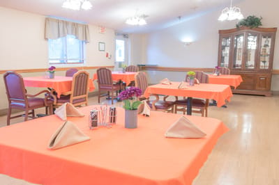 Dining area with orange tablecloths and flower centerpieces