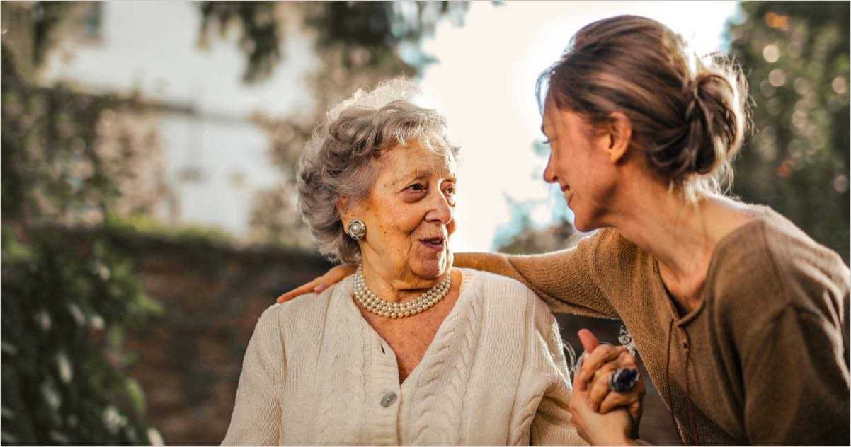 A caregiver and a resident enjoying a conversation outdoors