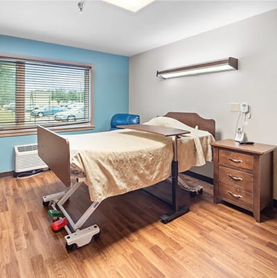 Good Samaritan Society Sioux Falls Village, Nursing Home in Sioux Falls, SD — Cozy senior bedroom with bed and wooden furniture