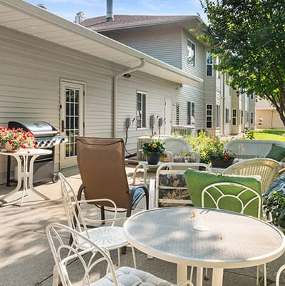 Good Samaritan Society Sioux Falls Village, Nursing Home in Sioux Falls, SD — Outdoor seating area with tables and greenery