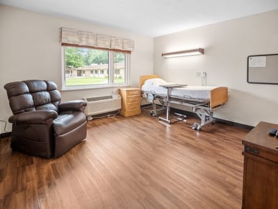 Good Samaritan Society Sioux Falls Village, Nursing Home in Sioux Falls, SD — Cozy personal room with a hospital bed and chair
