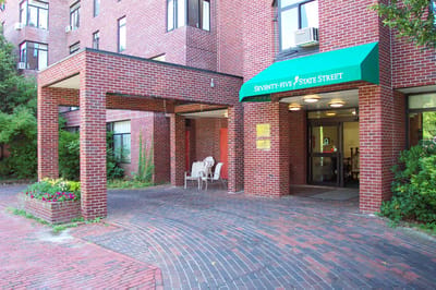 Entrance of a senior living facility with outdoor seating