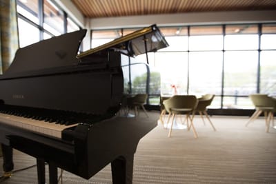 A grand piano in a well-lit common area